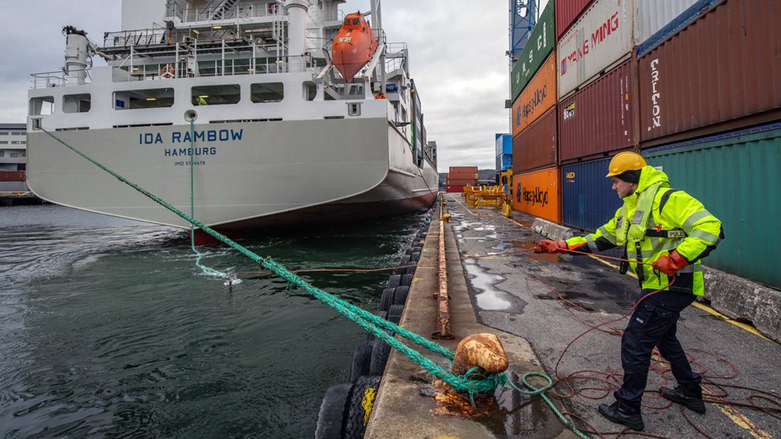 Mann fortøyar skip i pullert i Kristiansand hamn.